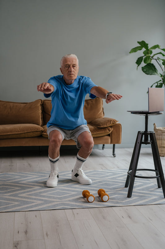 A senior man performing squats with dumbbells